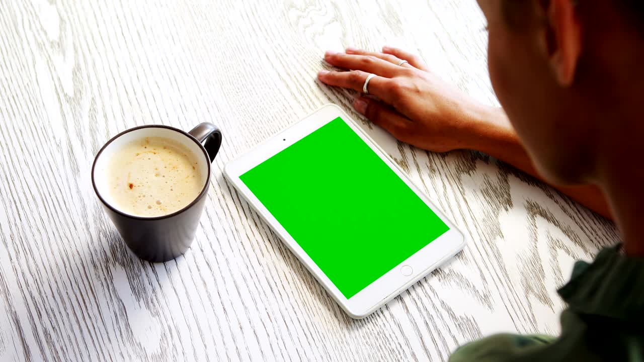 Donna che usa un tablet digitale mentre prende un caffè 4k