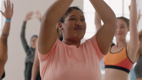 clase de yoga joven mujer de raza mixta con sobrepeso practicando pose guerrera disfrutando de un estilo de vida saludable compromiso instructor de fitness enseñando meditación grupal diversa en el estudio