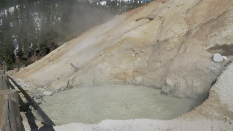 boiling muddpot with sulfuric smelling steam rising above at lassen volcanic national park