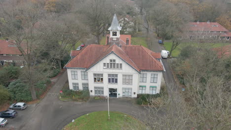 Drohne-Fliegt-Im-Herbst-Vom-Alten-Herrenhaus-Mit-Uhrturm-Weg