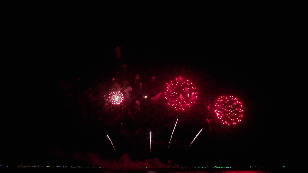 cielo nocturno en una playa llena de luces brillantes de colores para una exhibición de pirotecnia en un festival internacional de fuegos artificiales en el sudeste asiático