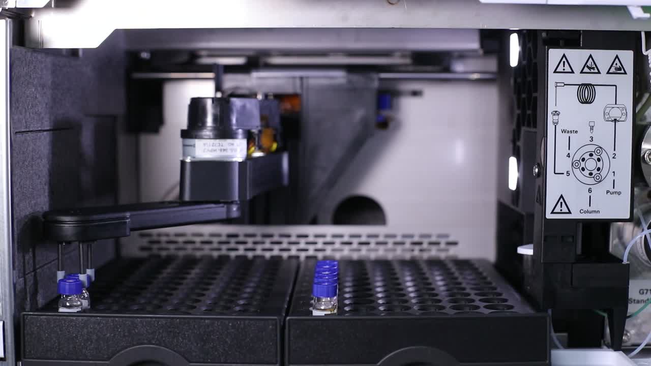 el brazo robótico recoge una botella de vacuna, la llena y la vuelve a poner