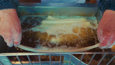 freshly fried food being prepared in wuzhen, china, showing golden fried items in oil