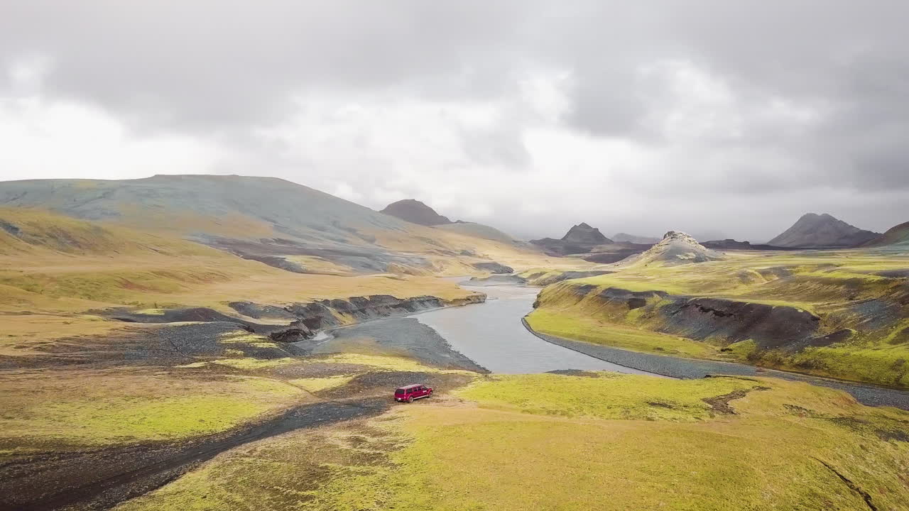 Icelandic Mountain Valley with River and Red Car
