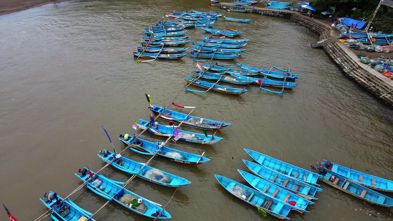 toma aérea de arriba hacia abajo de un barco pesquero tradicional anclado en el puerto de baron beach, yogyakarta