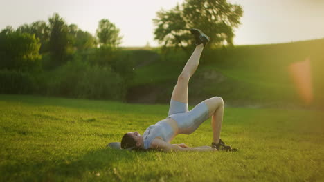 young woman doing single leg hip lifts. fitness woman doing bodyweight glute single leg floor bridge lift exercises.