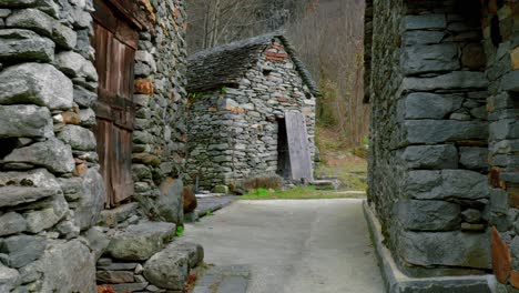 Fly-through-drone-shot-of-the-stone-houses-in-the-village-of-Cavergno,-located-in-the-district-of-Vallemaggia,-in-the-canton-of-Ticino-in-Switzerland