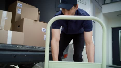 Video-of-courier-checking-and-unloading-package-on-the-hand-truck