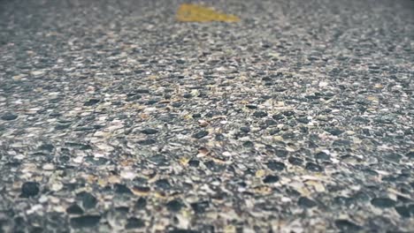 close-up of a faded yellow line on a cracked asphalt road