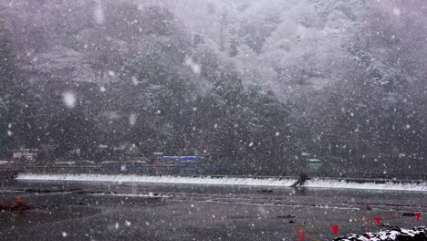 snowflakes over katsura river at arashiyama, kyoto