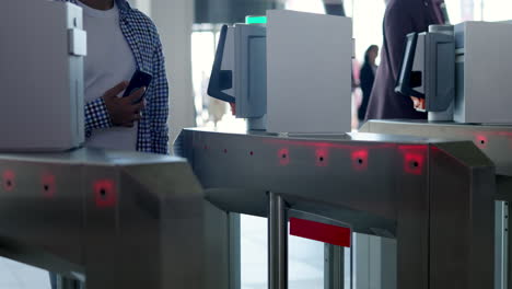 person using smartphone for entry at a turnstile