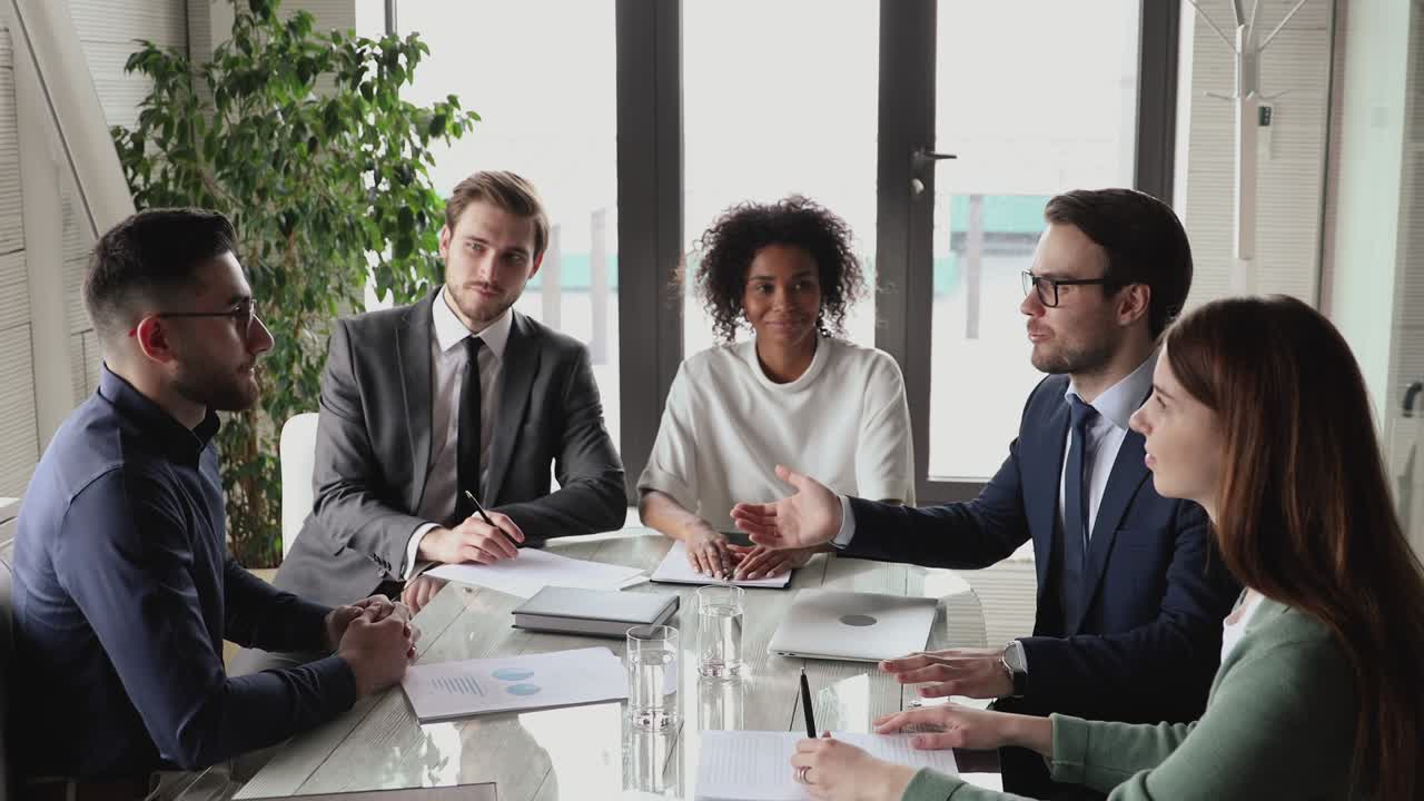 Smiling caucasian and arab business partners handshake at group meeting
