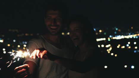 the happy couple holding sparklers lights outdoor. slow motion