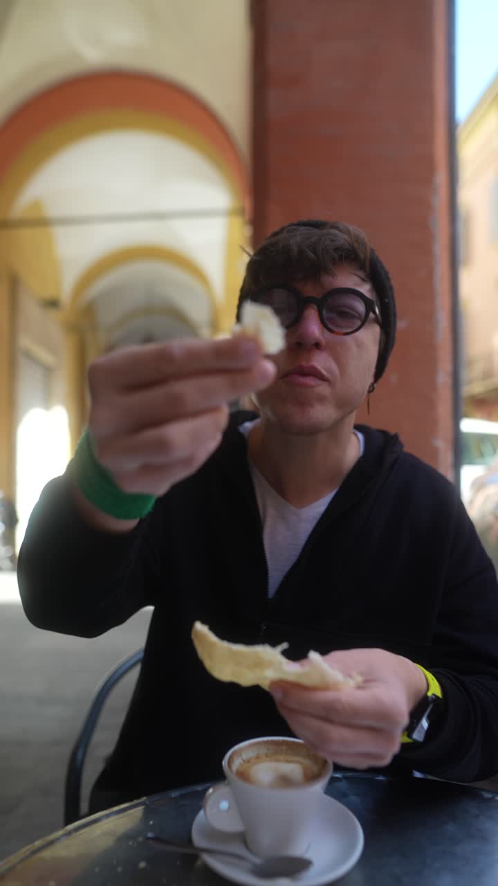 Person Eating Bread and Coffee in an Outdoor Cafe