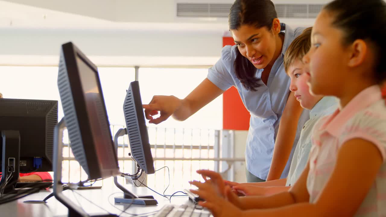 Asian female teacher teaching schoolkids on computer in the school 4k