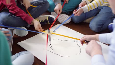 group of kids trying to draw with one marker