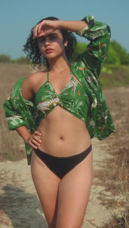 confident woman posing outdoors in bikini and green shirt, summer fashion mood