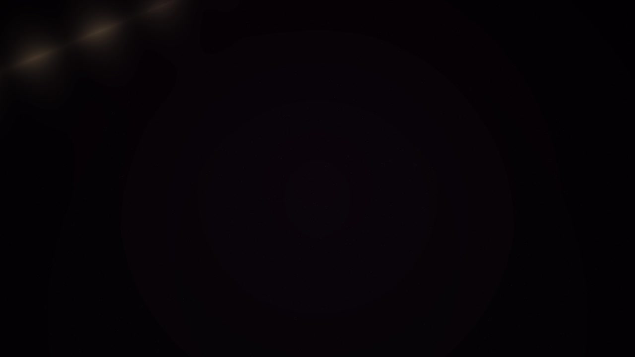 Subtle Dust Particles Floating with Golden Lens Flare on Black Background