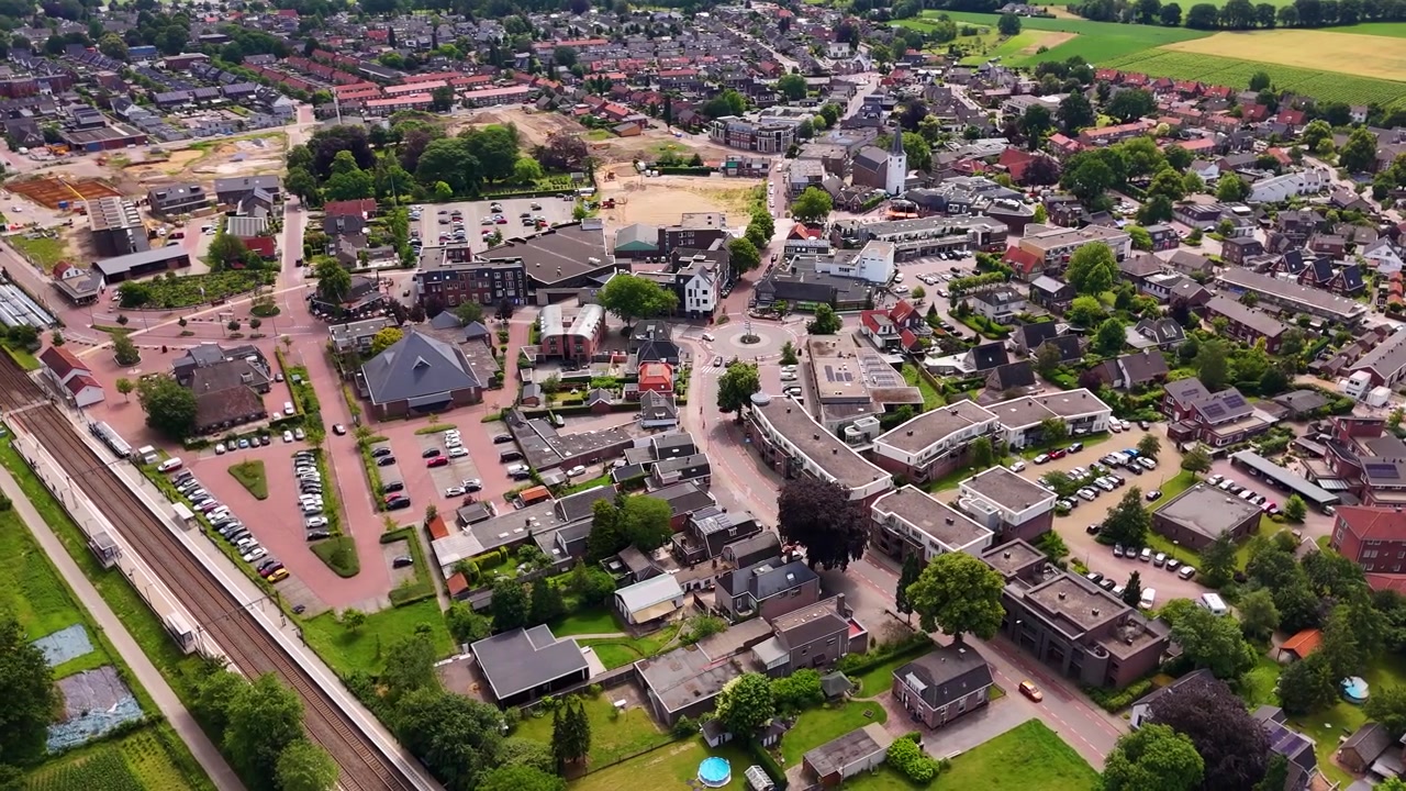 Luftaufnahme einer kleinen europäischen Stadt mit Eisenbahnschienen.