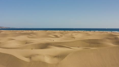 Drone-shot-of-desert-and-dunes-with-beach-and-sea,-dunas-de-maspalomas,-gran-canaria