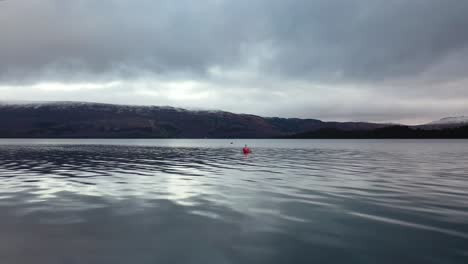 vista de drones de bajo vuelo en loch lomond hacia gaviota en boya