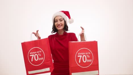 Woman in Santa Hat Presenting Holiday Discounts on Shopping Bags