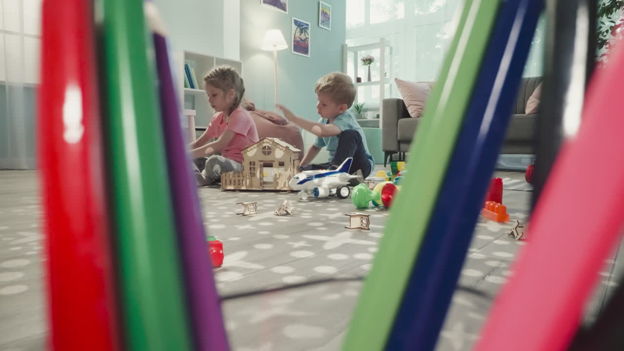 子供たちがプラスチックの組み立てブロックで構造物を作る。