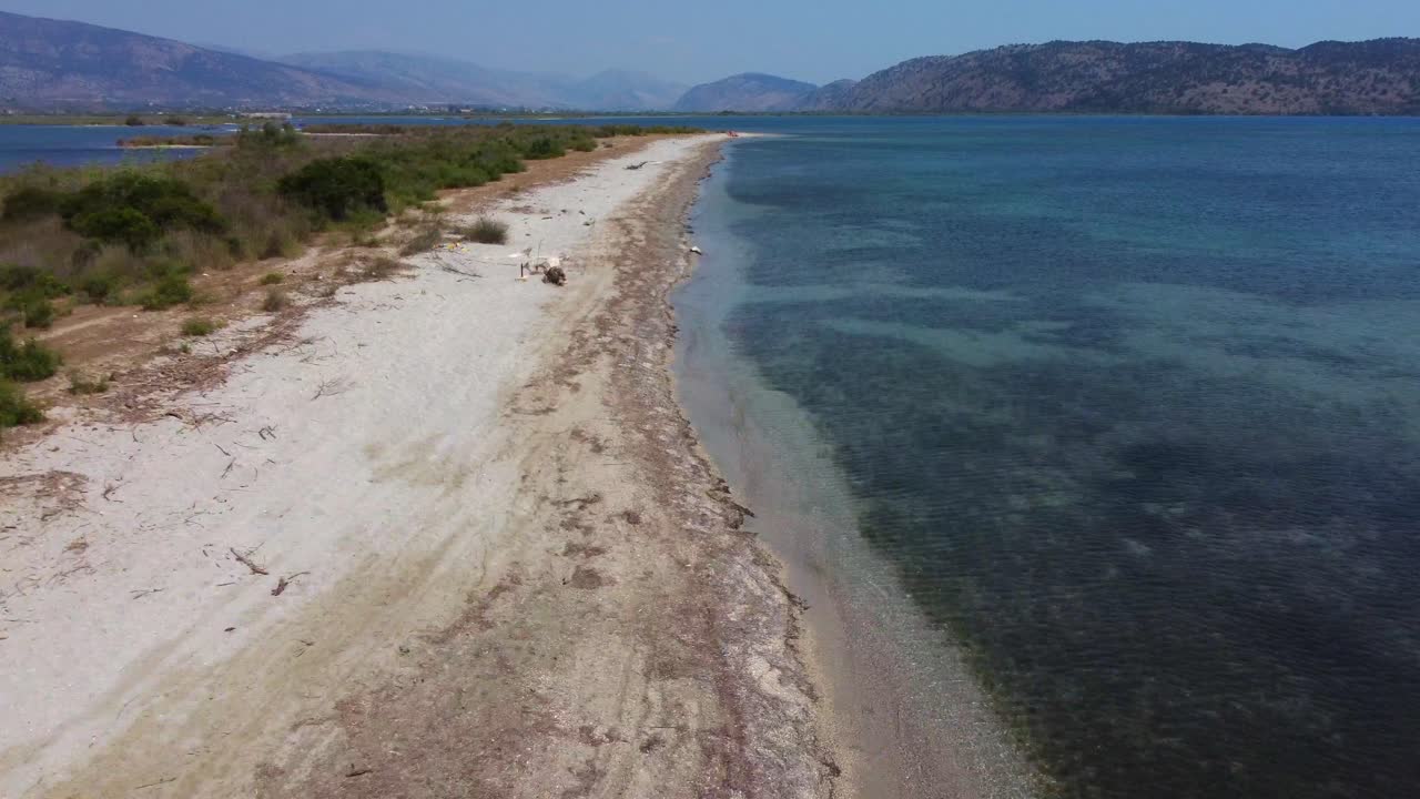 Drone shot of a lonely beach on the Albanian coast - drone is following the beach line, ending in the Mediterranean sea