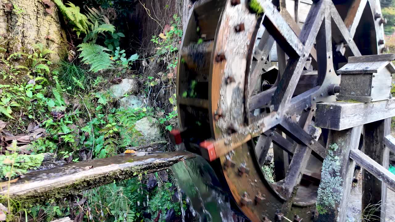 Wooden water wheel rotating by the force of water in the preserved post town of Magome juku, Kiso Valley, Japan