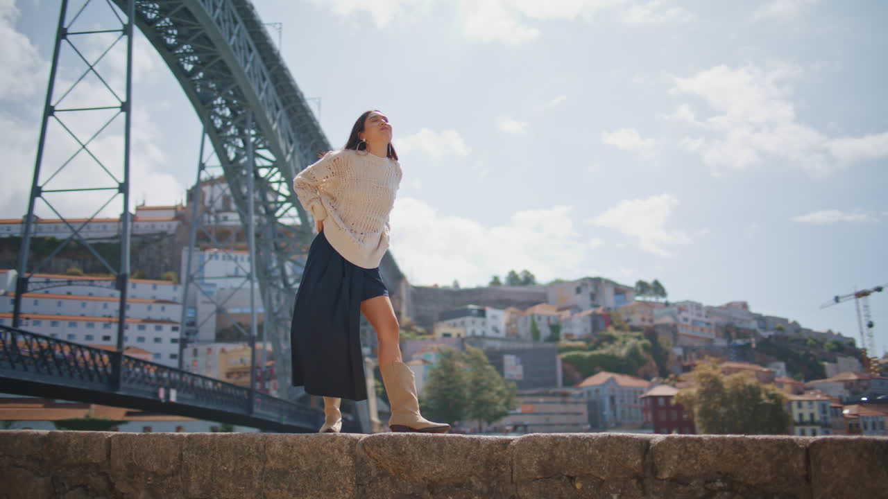 Tourist lady contemplating cityscape strolling stoned promenade on sunny day