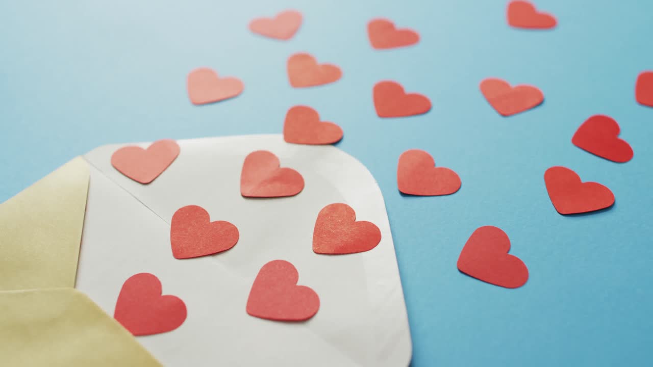 Envelope with paper hearts on blue background at valentine's day