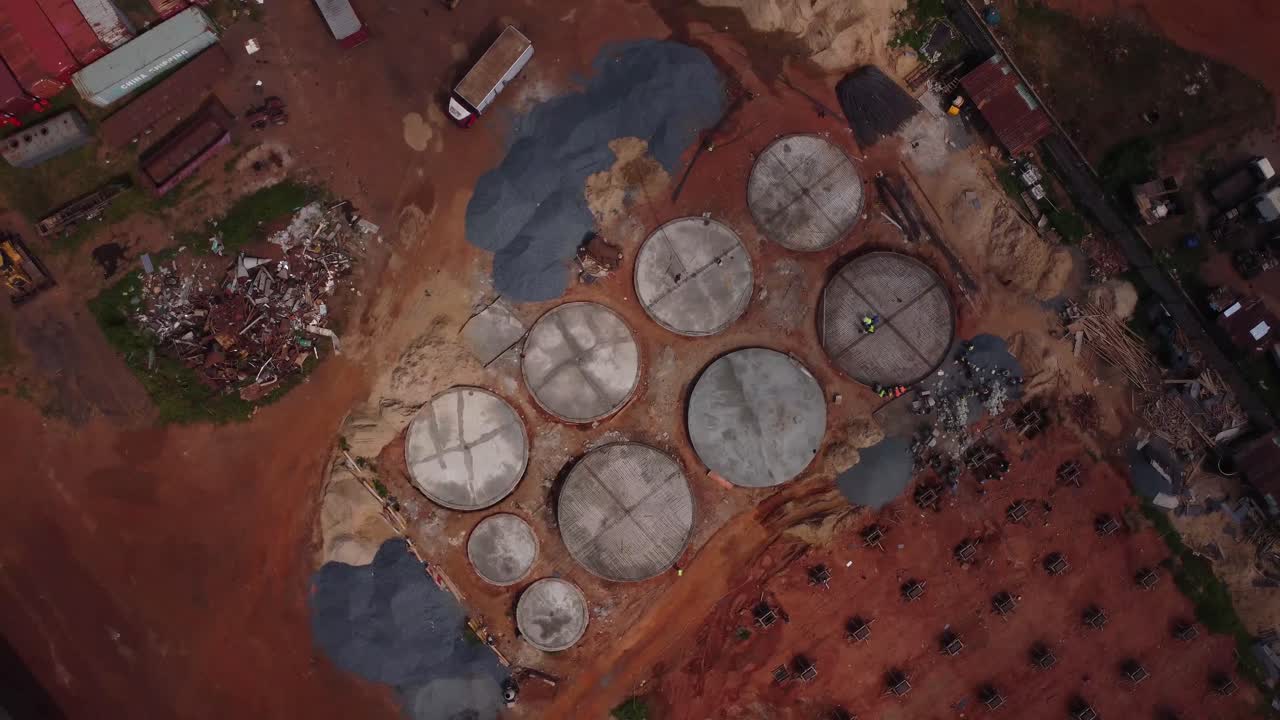 Circular concrete structures at industrial construction site near Lagos highway