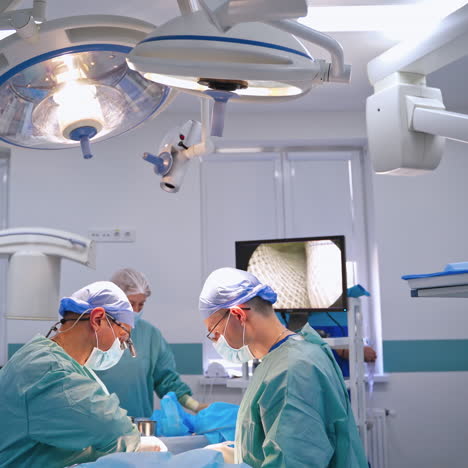 two surgeons and assistant in the operating room. modern equipment in clinic and advanced doctors perform a surgery in clinic.