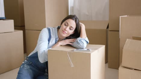 una mujer joven tomando una siesta en un cartón marrón