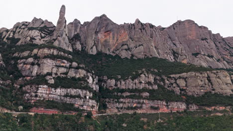 Drone-push-in-shot-of-great-epic-green-cliff-peaks-on-tranquil-overcast-day