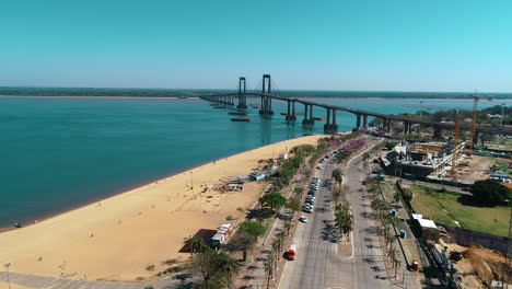 a panoramic view of the city of corrientes, its beach, riverside promenade , and the bridge connecting it to resistencia, highlighting the beauty of this argentinean urban landscape