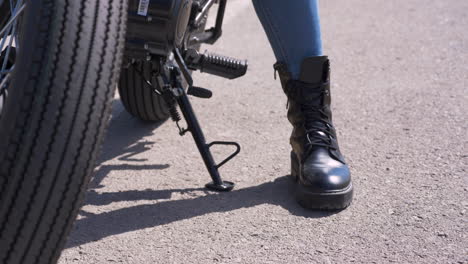 primer plano de un motociclista irreconocible recogiendo el pie de apoyo y listo para funcionar