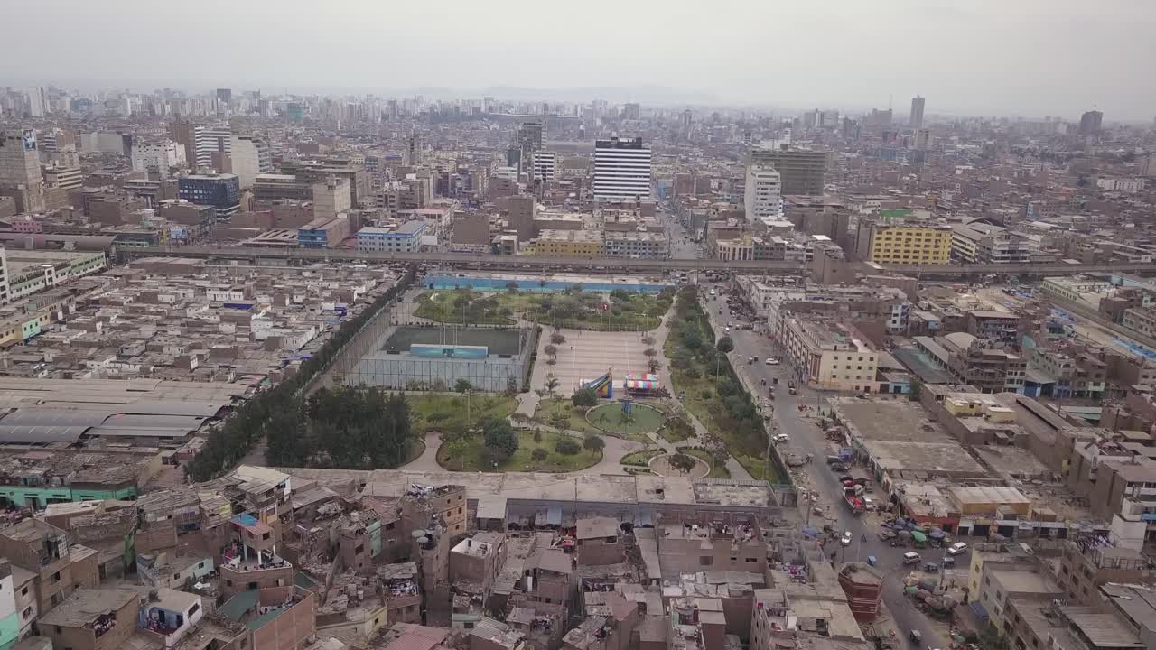 Aerial view of a city with a central park, sports courts, and surrounding urban housing. Perfect for editorial, real estate, and urban planning visuals.