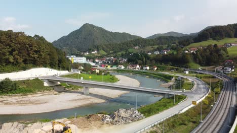 vista de drones del río entre las carreteras en marija gradec, laško con montañas en el fondo, eslovenia