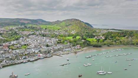 Un-Gran-Número-De-Veleros-Y-Embarcaciones-A-Motor-Están-Amarrados-En-El-Largo-Embarcadero-Del-Río-Que-Fluye-Rápido-Frente-A-La-Ciudad-Inglesa-De-Conwy-Entre-Las-Verdes-Colinas-De-Gales-En-Un-Día-Nublado