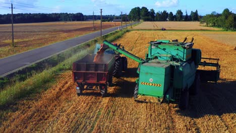 Cosechadora-Depositando-Trigo-En-Un-Remolque-De-Tractor---Disparo-De-Drones