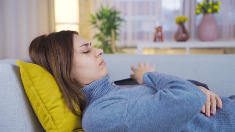 Una-Mujer-Joven-Que-Mira-Su-Teléfono-Inteligente-En-El-Sofá-Está-Infeliz-Y-Deprimida.