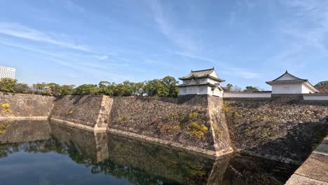 calm water reflects a historic japanese castle.