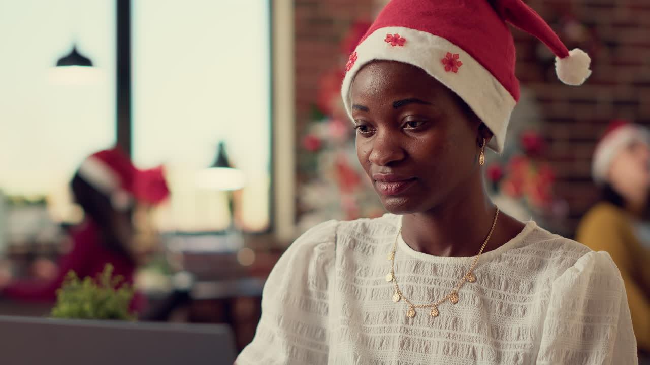 Female worker analyzing data on laptop in festive office