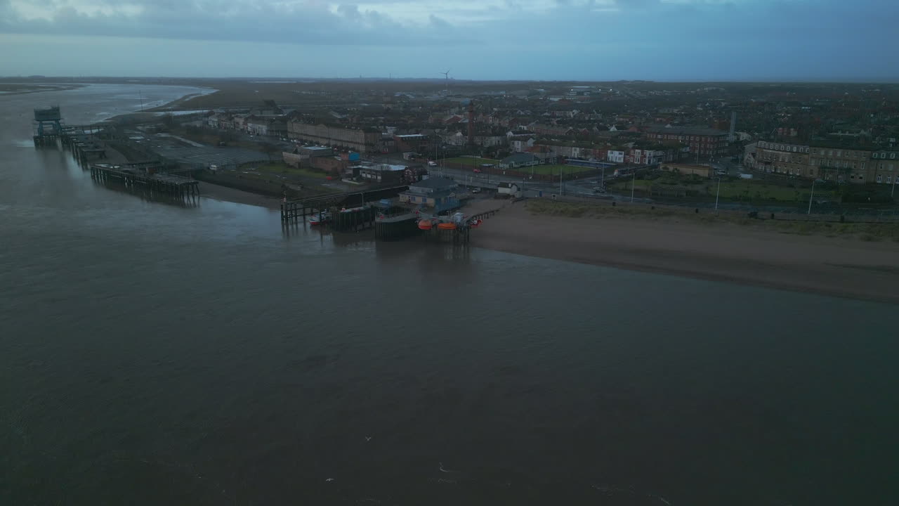 el puerto pesquero urbano de fleetwood se revela sobre el río wyre y la estación de botes salvavidas rnli al amanecer.