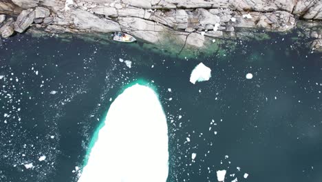 floating iceberg on deep ocean water surface near greenland coast, aerial view