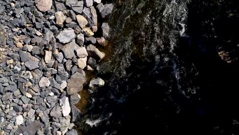 Un-Río-Fluye-Pesado-Junto-A-Una-Carretera-Mientras-El-Dron-Desciende-Los-Autos-Pasan