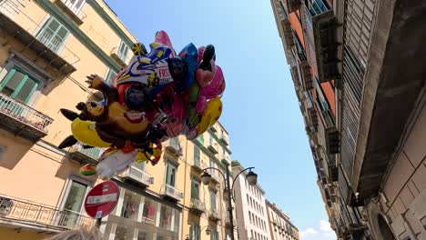 colorful balloons rising between buildings in naples