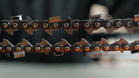 a closeup shot of a chain of a chainsaw, with a blurred background