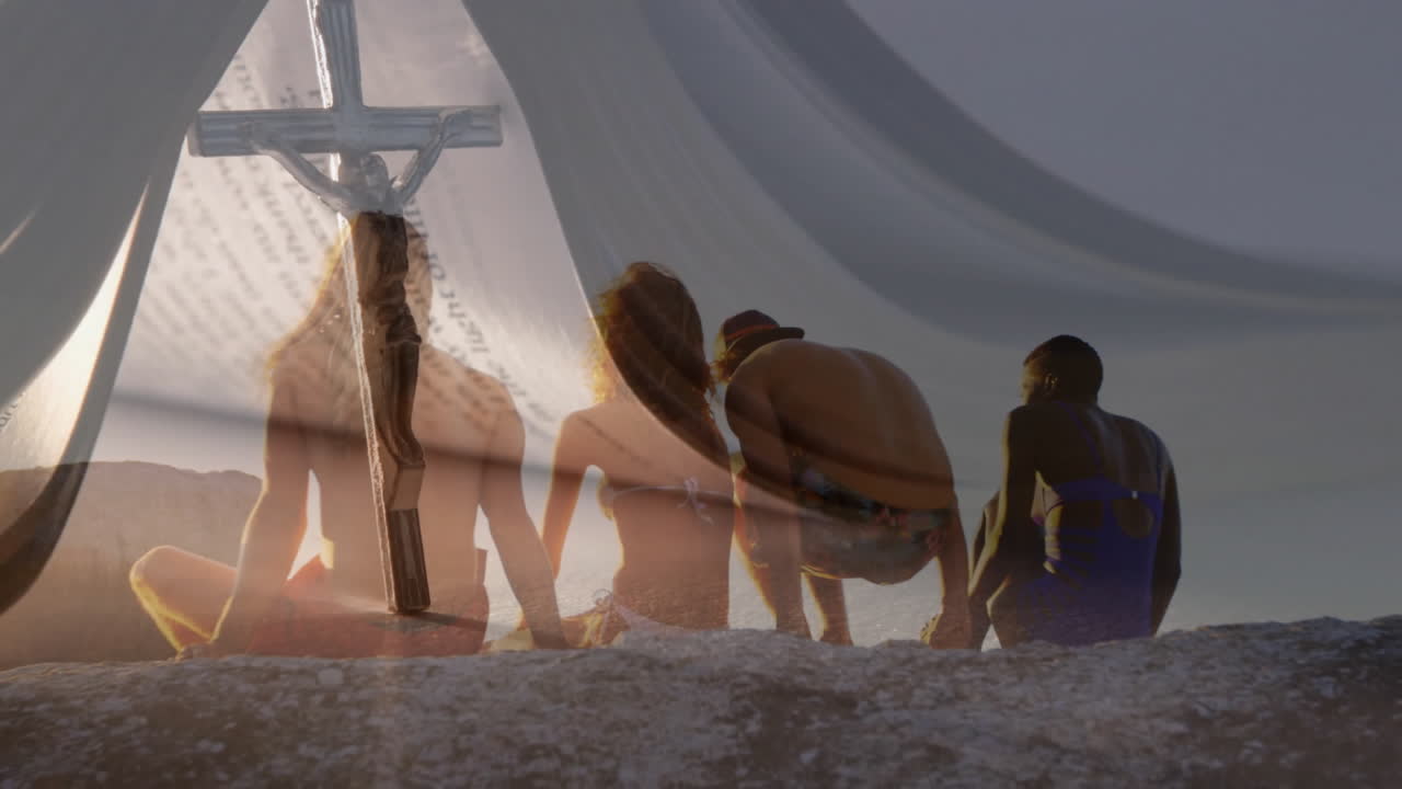 Sitting on beach, silhouetted group with cross and animation text overlay
